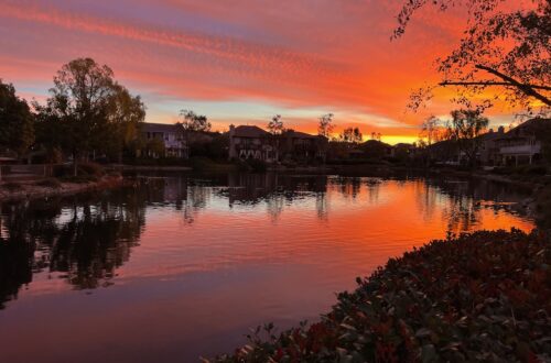 Sunrise over lake with pink and orange clouds. Words of Intention for new year- presence